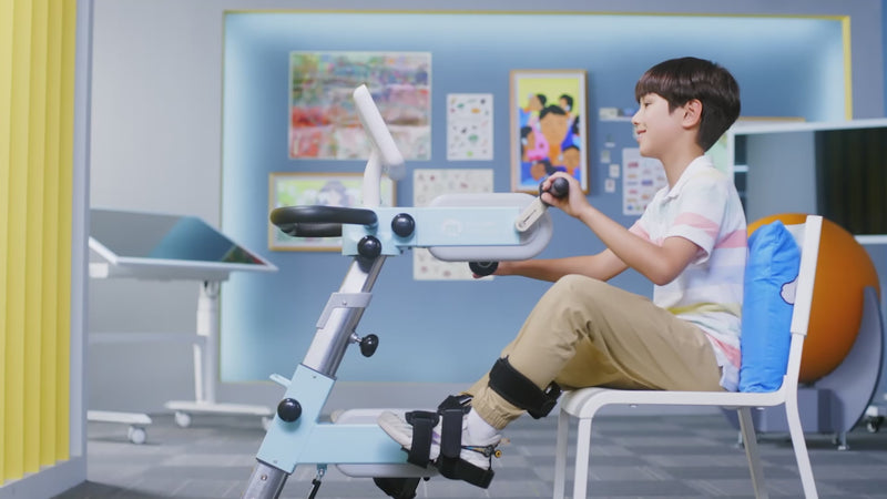 Child using CycleMotus A4K rehab trainer for arm and leg movement therapy